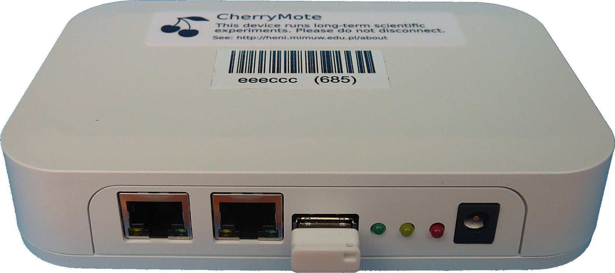 A photo of CherryMote. It is a small white box with Ethernet ports, a USB port, LEDs and a power supply port in the front panel.